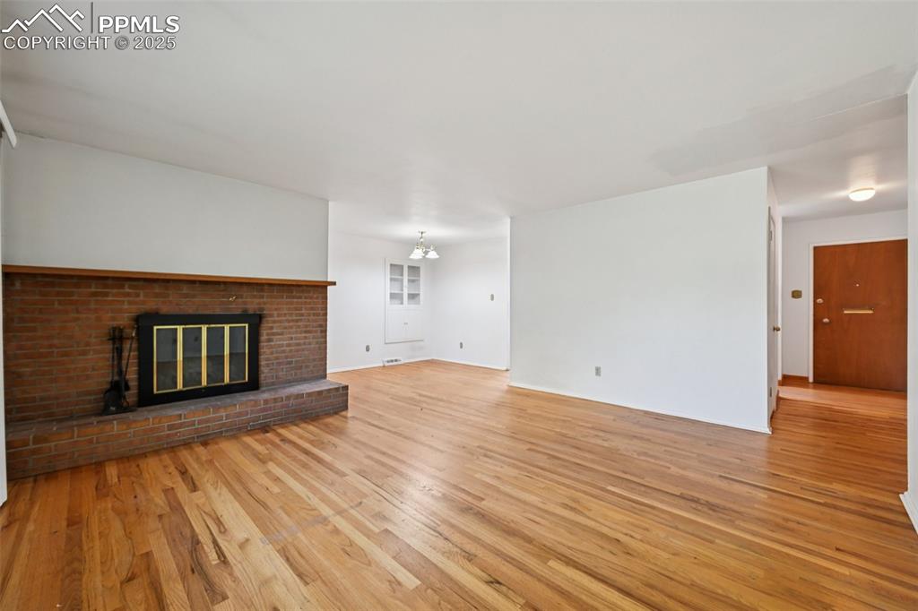 2977 South Oneida Street Denver, CO 80224 - Photo 12 of 50 a view of an empty room with wooden floor and a fireplace