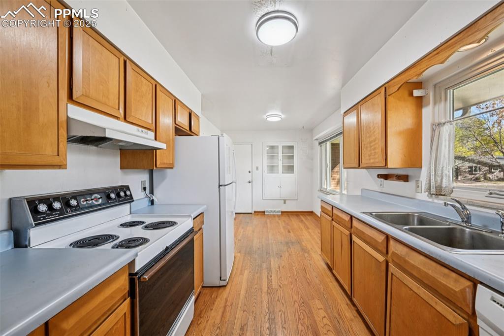 2977 South Oneida Street Denver, CO 80224 - Photo 19 of 50 a kitchen that has a sink a stove and cabinets