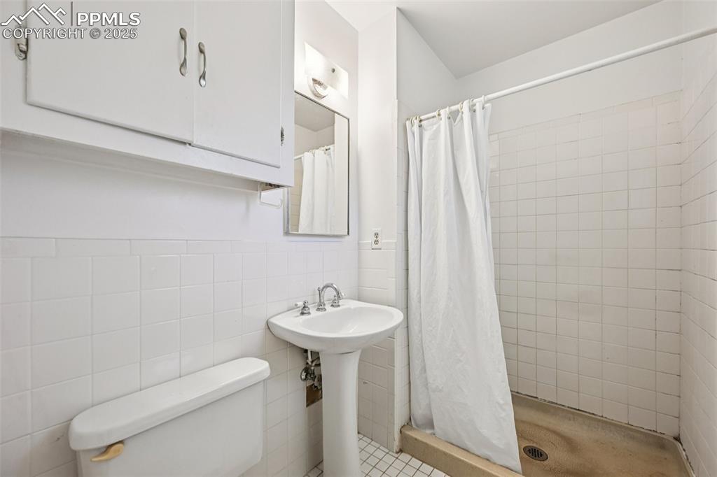2977 South Oneida Street Denver, CO 80224 - Photo 28 of 50 a bathroom with a sink a toilet and shower