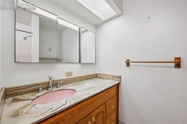 a bathroom with a granite countertop sink and a mirror