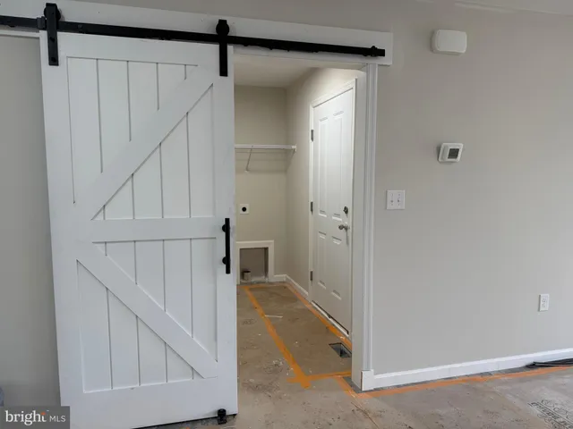 a view of a hallway with white walls and entryway