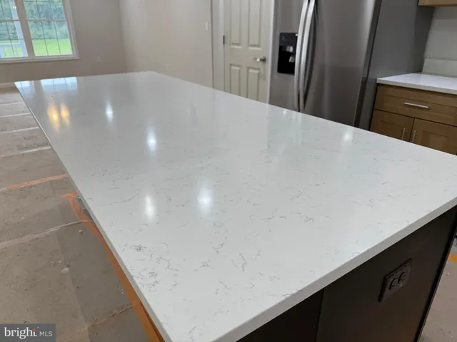 a kitchen with kitchen island a sink stainless steel appliances and refrigerator