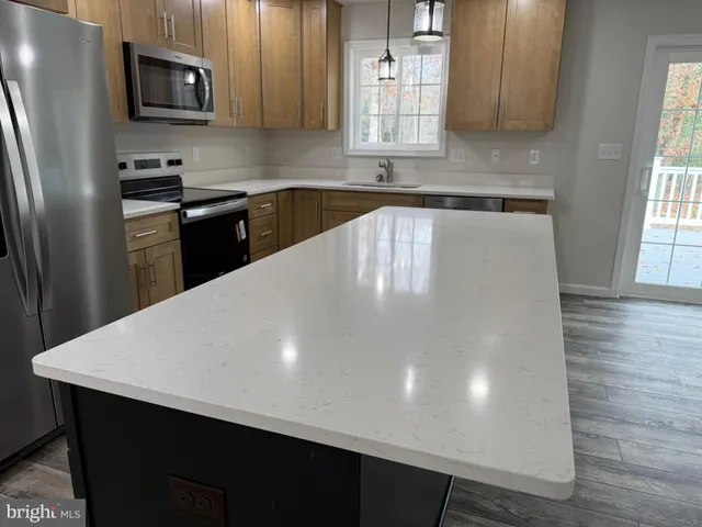 a kitchen with stainless steel appliances a refrigerator sink and microwave