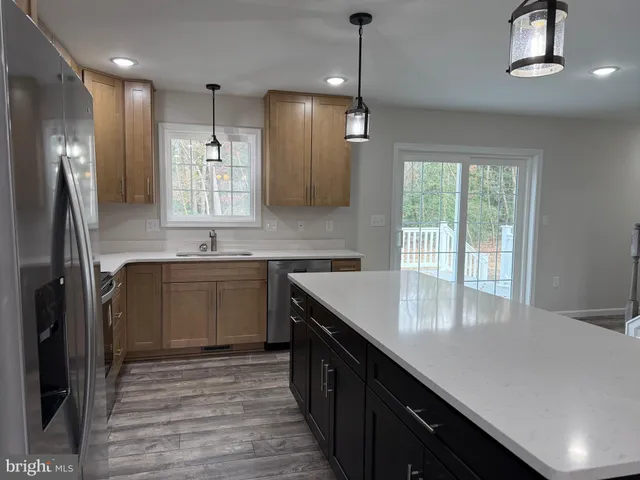a kitchen with kitchen island granite countertop a sink appliances cabinets and a counter top space