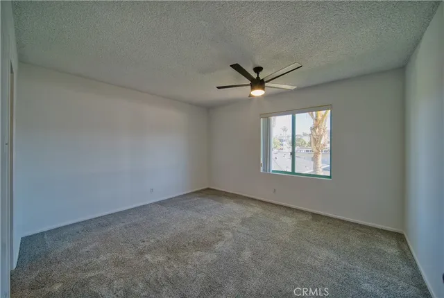 an empty room with a window and a fan