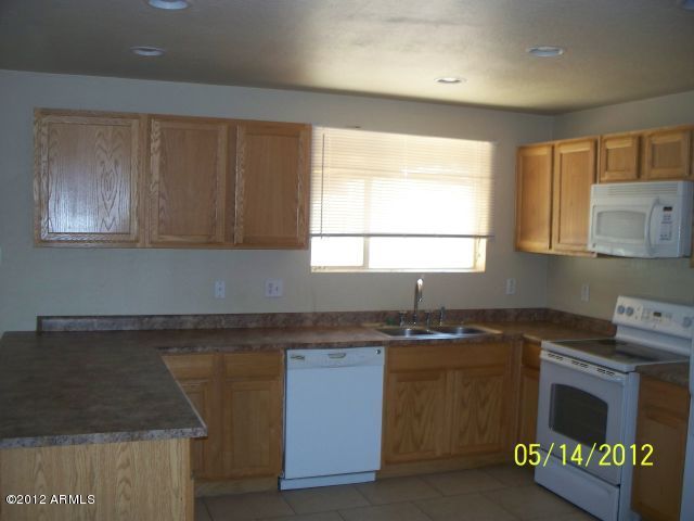 4837 West Osborn Road Phoenix, AZ 85031 - Photo 9 of 14 a kitchen with granite countertop cabinets stainless steel appliances a sink and a window