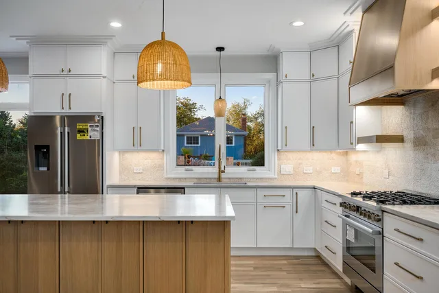 a kitchen with stainless steel appliances granite countertop a sink a stove and cabinets