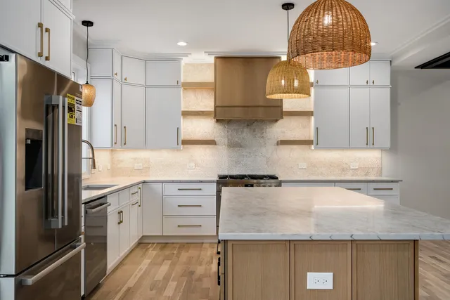 a kitchen with stainless steel appliances granite countertop a sink a stove and a refrigerator