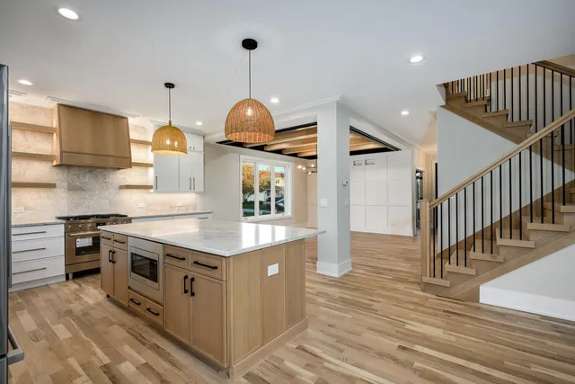 a kitchen with stainless steel appliances granite countertop a sink a stove and a wooden floors