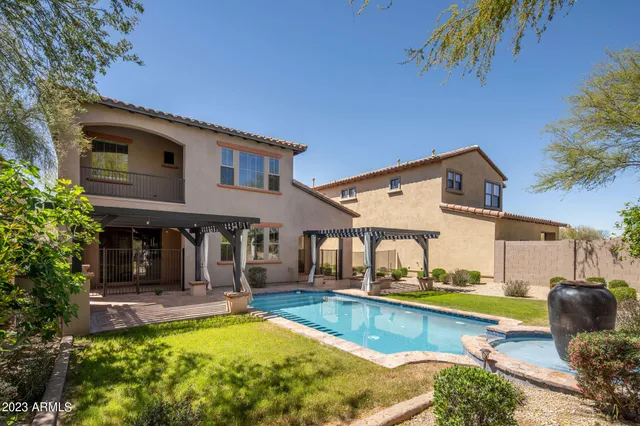 a view of a house with swimming pool and a chairs