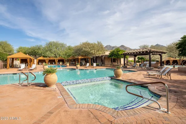 a view of a house with swimming pool and sitting area