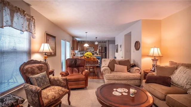 a living room with furniture a flat screen tv and kitchen view