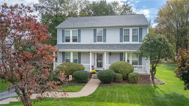 a front view of a house with yard and green space
