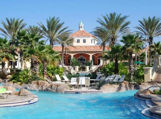 a swimming pool with outdoor seating yard and palm tree