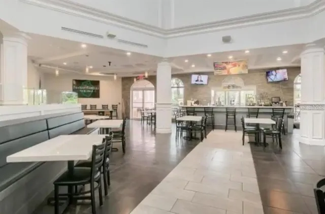 a dining hall with stainless steel appliances lots of white furniture a dining table and chairs