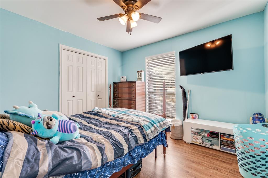 1509 Springbrook Street Corinth, TX 76210 - Photo 21 of 24 a bedroom with a bed a flat screen tv and a chandelier