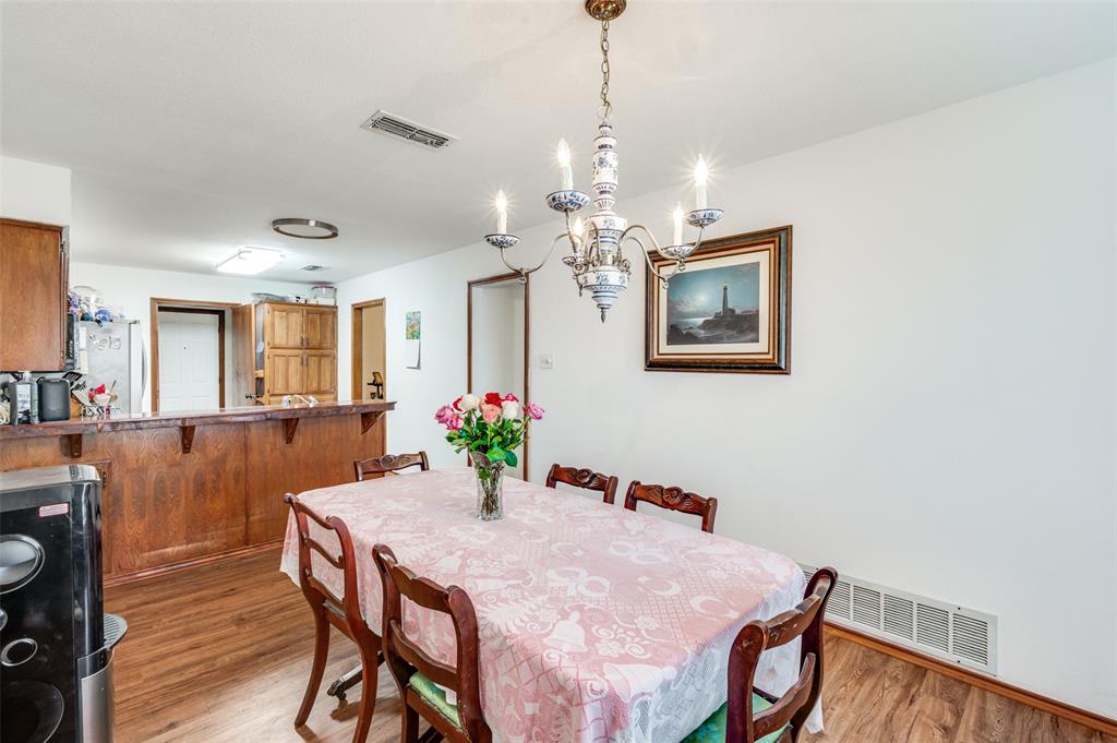 1509 Springbrook Street Corinth, TX 76210 - Photo 6 of 24 a view of a dining room with furniture and wooden floor