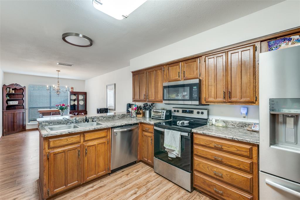 1509 Springbrook Street Corinth, TX 76210 - Photo 9 of 24 a kitchen with stainless steel appliances granite countertop a stove sink and cabinets