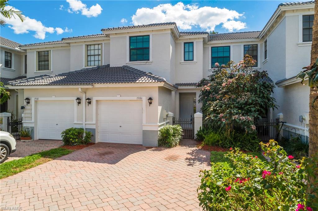15186 Summit Pl Circle Naples, FL 34119 - Photo 1 of 37 Mediterranean / spanish-style home featuring decorative driveway, a tiled roof, stucco siding, and a gate
