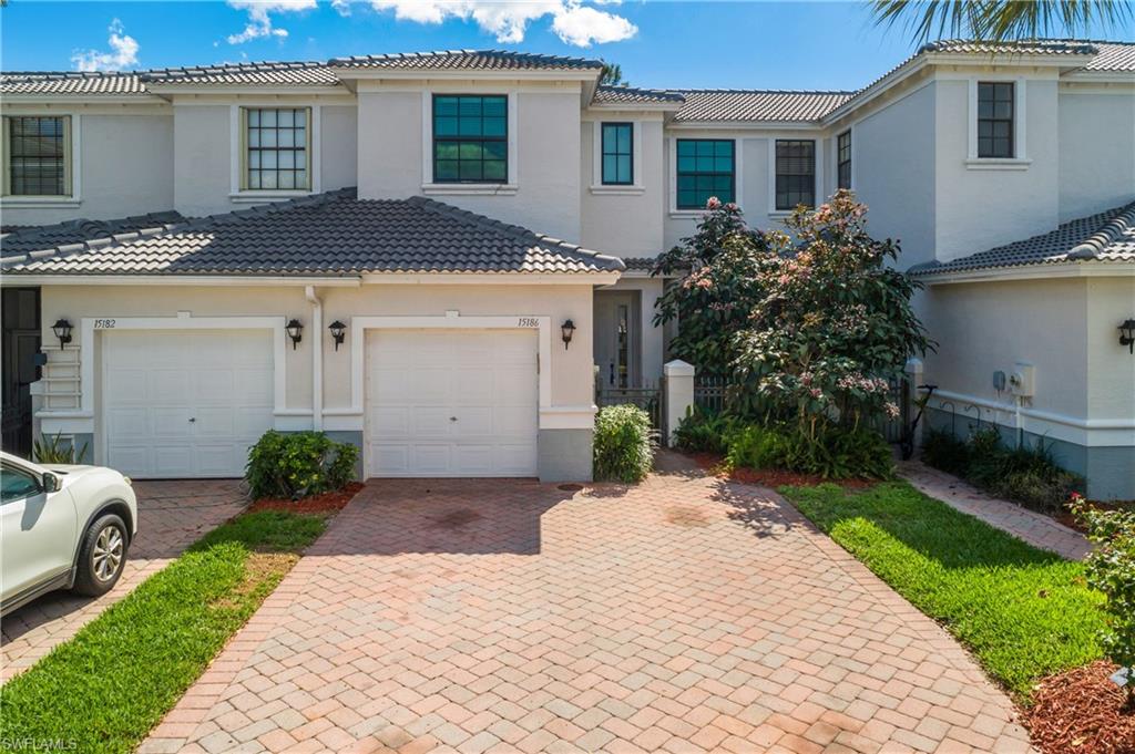 15186 Summit Pl Circle Naples, FL 34119 - Photo 19 of 37 a front view of a house with a yard