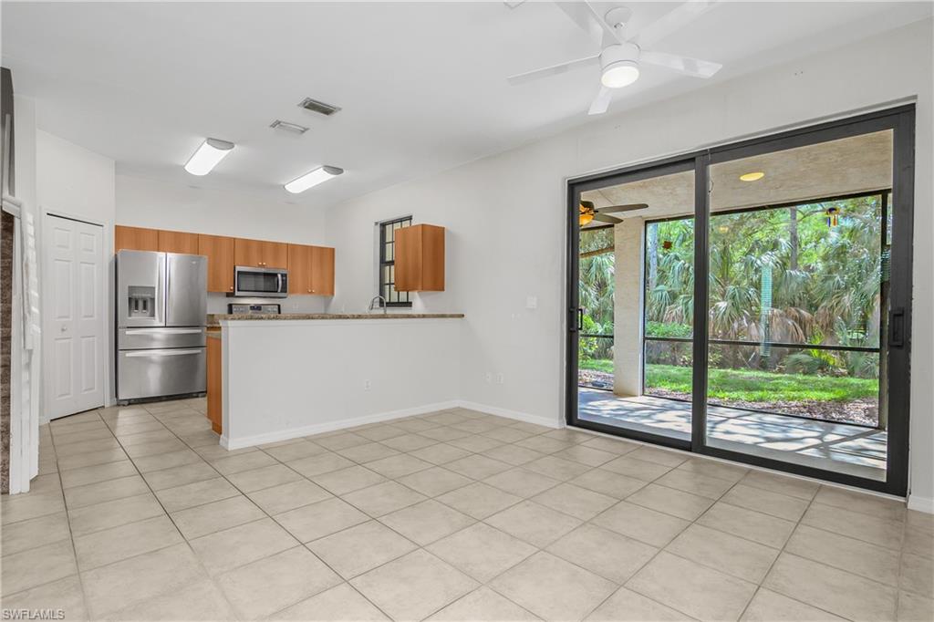 15186 Summit Pl Circle Naples, FL 34119 - Photo 24 of 37 a kitchen with stainless steel appliances kitchen island granite countertop a refrigerator and a sink