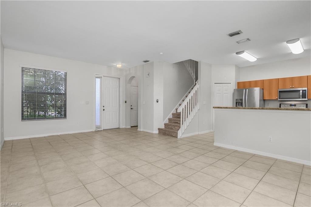 15186 Summit Pl Circle Naples, FL 34119 - Photo 25 of 37 a view of an empty room with kitchen view and a window
