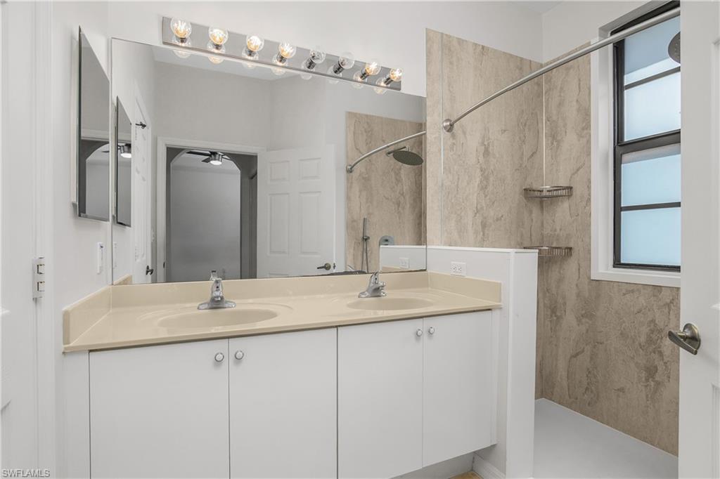 15186 Summit Pl Circle Naples, FL 34119 - Photo 27 of 37 a bathroom with a sink and a mirror