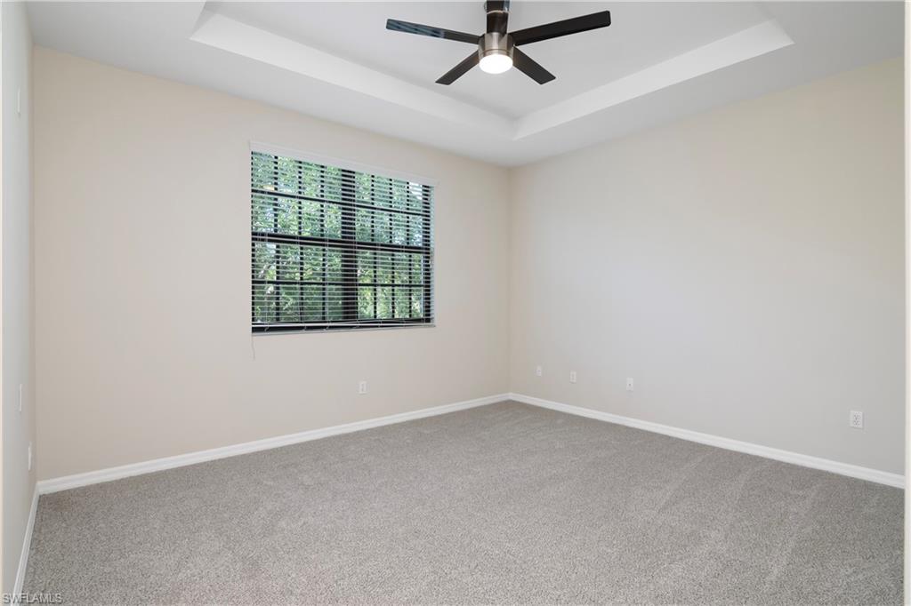 15186 Summit Pl Circle Naples, FL 34119 - Photo 29 of 37 an empty room with ceiling fan and windows