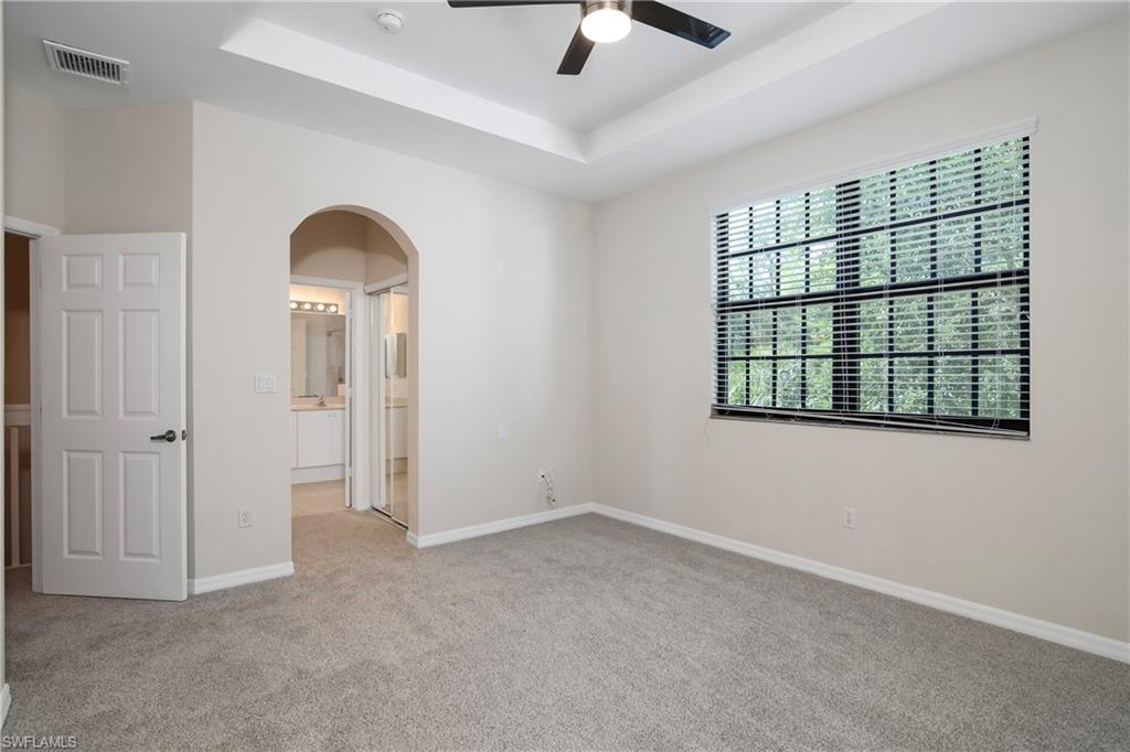 15186 Summit Pl Circle Naples, FL 34119 - Photo 30 of 37 an empty room with chandelier fan and windows