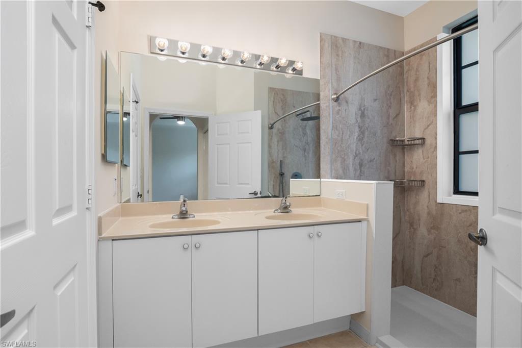 15186 Summit Pl Circle Naples, FL 34119 - Photo 37 of 37 a bathroom with a double vanity sink and mirror