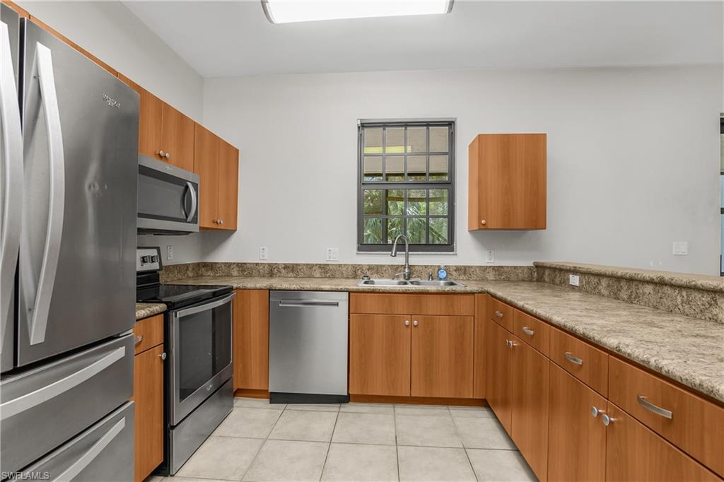 15186 Summit Pl Circle Naples, FL 34119 - Photo 8 of 37 a kitchen with stainless steel appliances granite countertop a sink stove and refrigerator