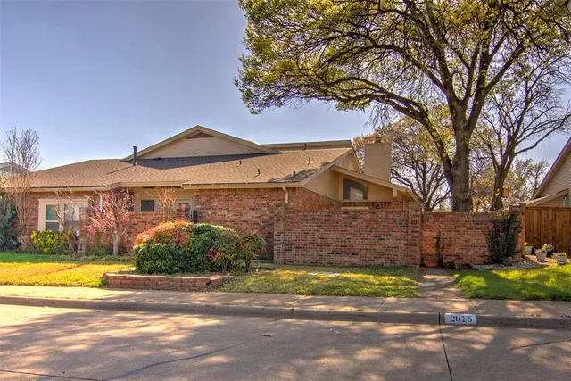 a view of a house with a yard and large tree