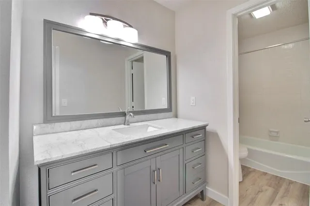 a bathroom with a granite countertop sink and a mirror