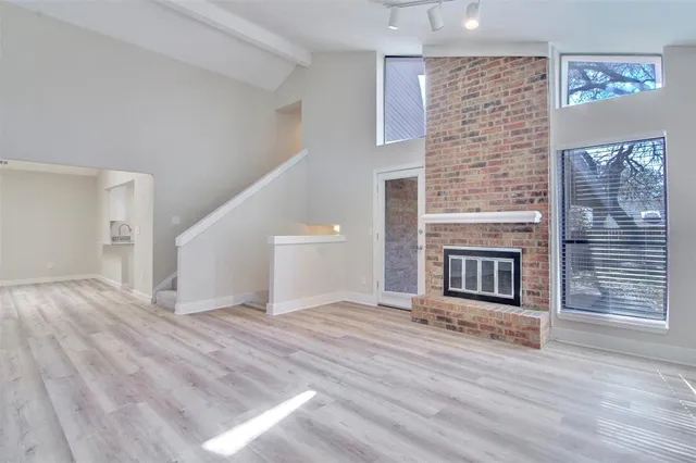 a view of empty room with wooden floor and fireplace
