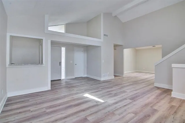 a view of empty room with wooden floor