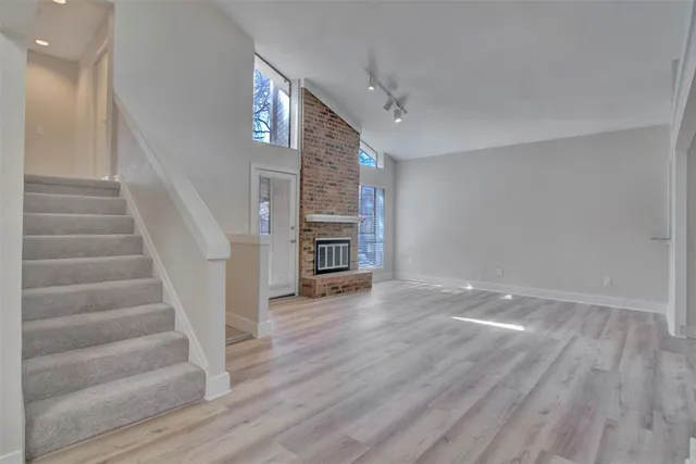 a view of empty room with wooden floor and stairs