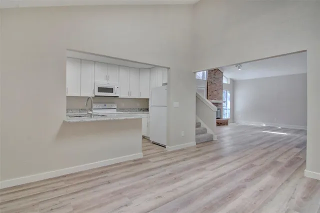 a view of a kitchen with wooden floor and a sink