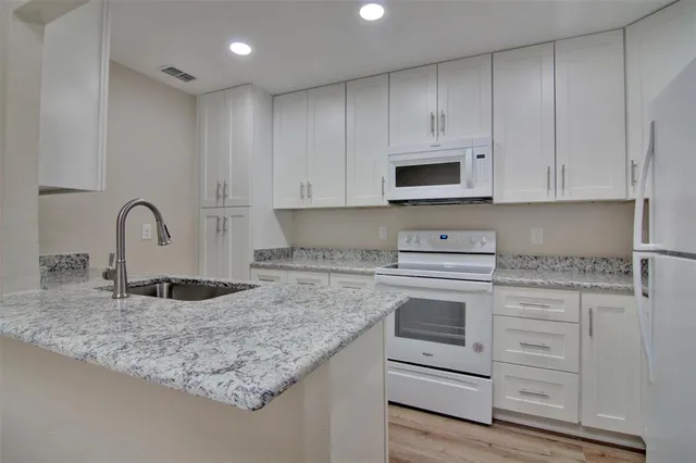 a kitchen with granite countertop a sink and a stove