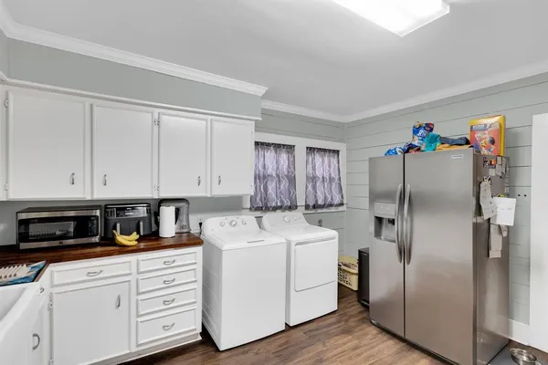 a kitchen with cabinets stainless steel appliances and wooden floor