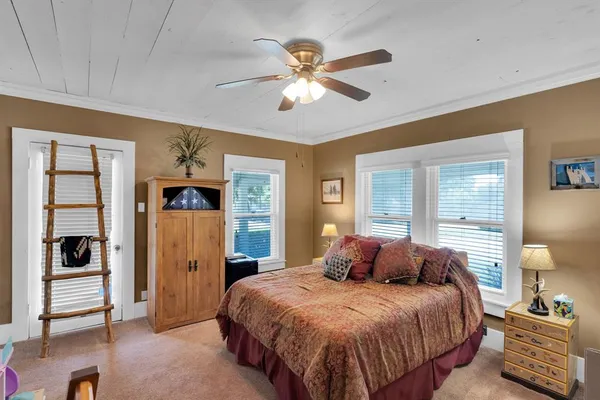 a bedroom with a large bed and a chandelier