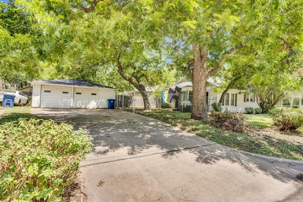 a backyard of a house with large trees and outdoor space