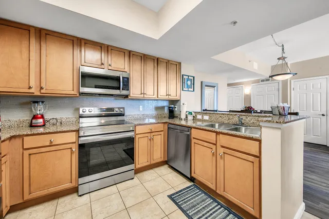 a kitchen with granite countertop a refrigerator stove and microwave