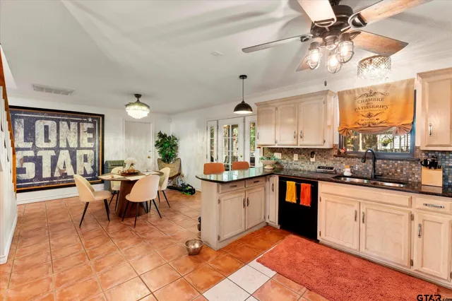 a large kitchen with kitchen island a sink table and chairs