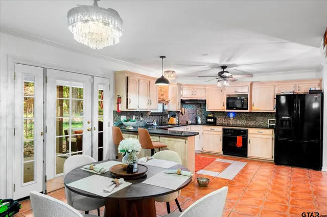 a kitchen with stainless steel appliances kitchen island granite countertop a sink and refrigerator