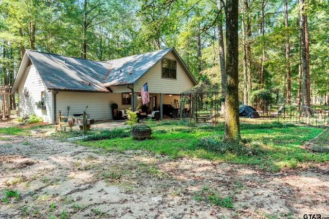 a view of a house with backyard and a tree