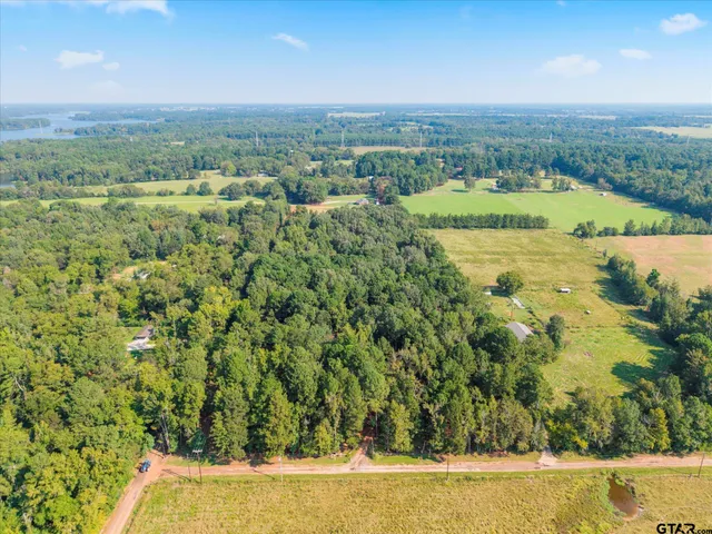 a view of a lush green field with lots of buildings in the background