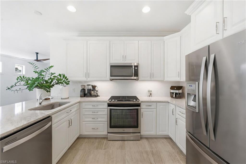 7733 Jacaranda Lane Naples, FL 34114 - Photo 11 of 38 a kitchen with a white stove and refrigerator