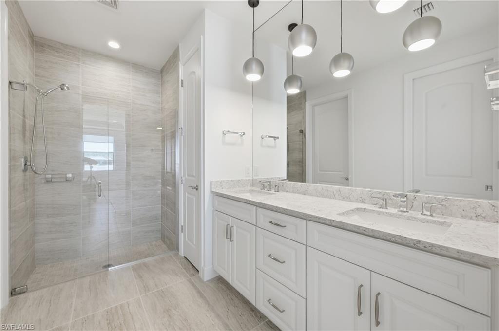 7733 Jacaranda Lane Naples, FL 34114 - Photo 14 of 38 a bathroom with a granite countertop sink mirror and shower