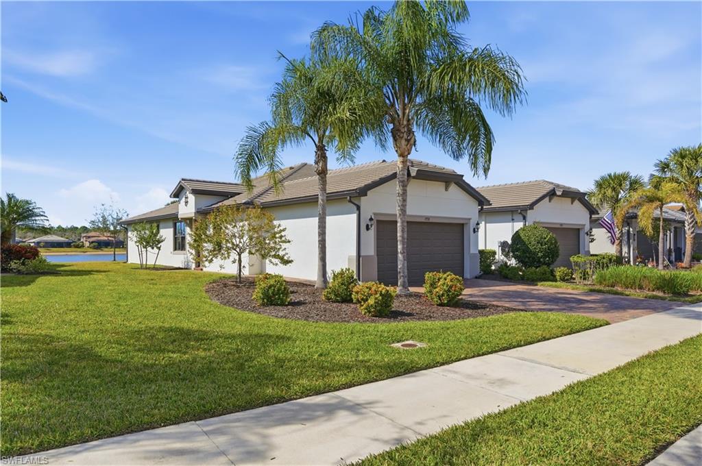 7733 Jacaranda Lane Naples, FL 34114 - Photo 2 of 38 a front view of house with yard and green space