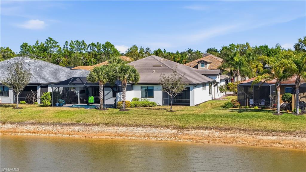 7733 Jacaranda Lane Naples, FL 34114 - Photo 30 of 38 a view of a house with a swimming pool and a yard